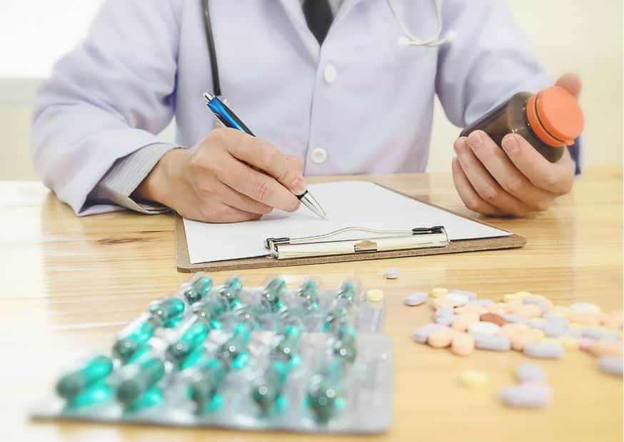 arts die medicatie voorschrijft met pillen op de voorgrond