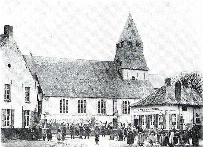 Foto uit 1903 net vóór de afbraak van de Romaanse kerk in Passendale. De herberg 'In Vlaanderen' met paardenstal is eigendom van brouwer-burgemeester Charles Bayart en wordt uitgebaat door Paul Grillet.