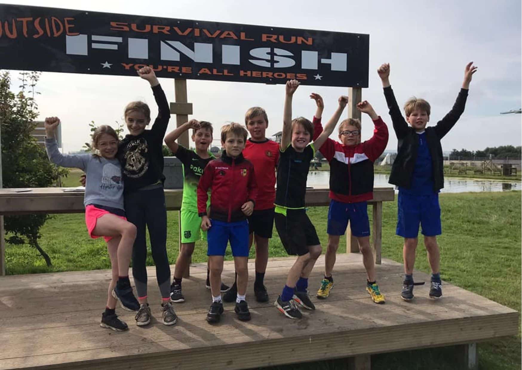 kinderen aan het juichen bij de finish van een survival run